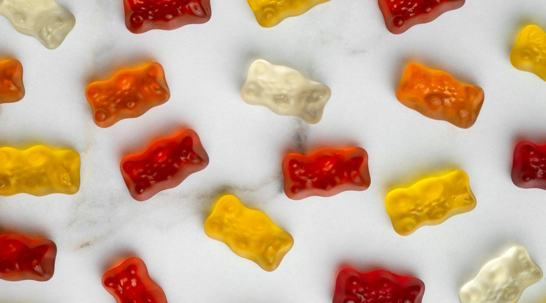 Assorted gummy bears neatly arranged in a pattern on a white surface, promoting gut health with fiber gummies